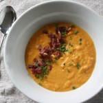 Sweet potato and bacon soup on grey placemat