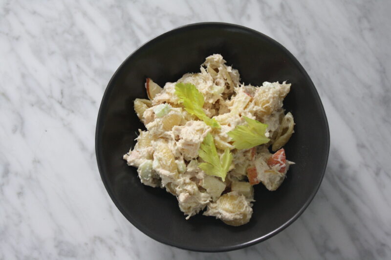 tuna pasta salad in black bowl on marble counter