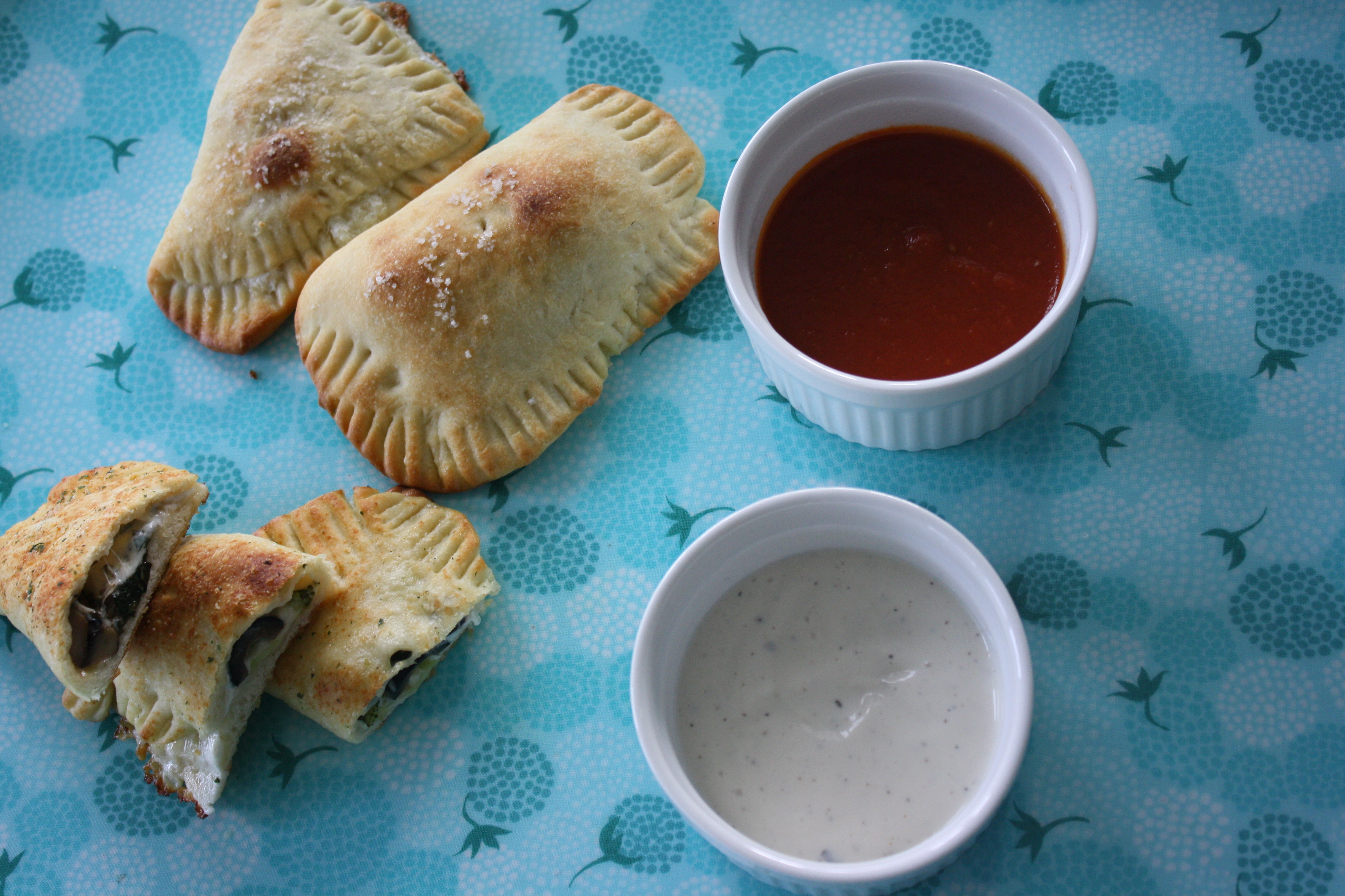 homemade pizza pockets on plate with dipping sauces