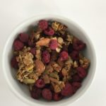 raspberry nut and seed granola in a white bowl