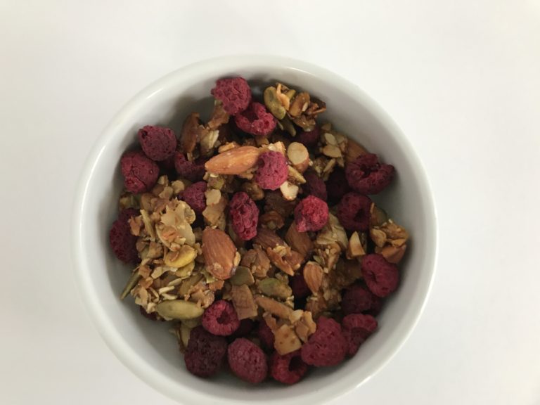 raspberry nut and seed granola in a white bowl
