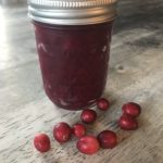 instant pot cranberry sauce in jar with cranberries on table