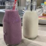 wild blueberry oat milk next to regular oat milk in jars