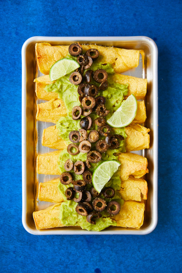 Olive and Refried Bean Taquitos on a pan with blue background