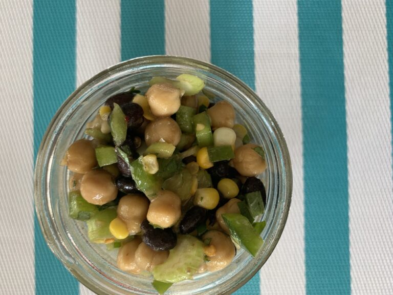 crazy good bean salad in bowl on striped placemat